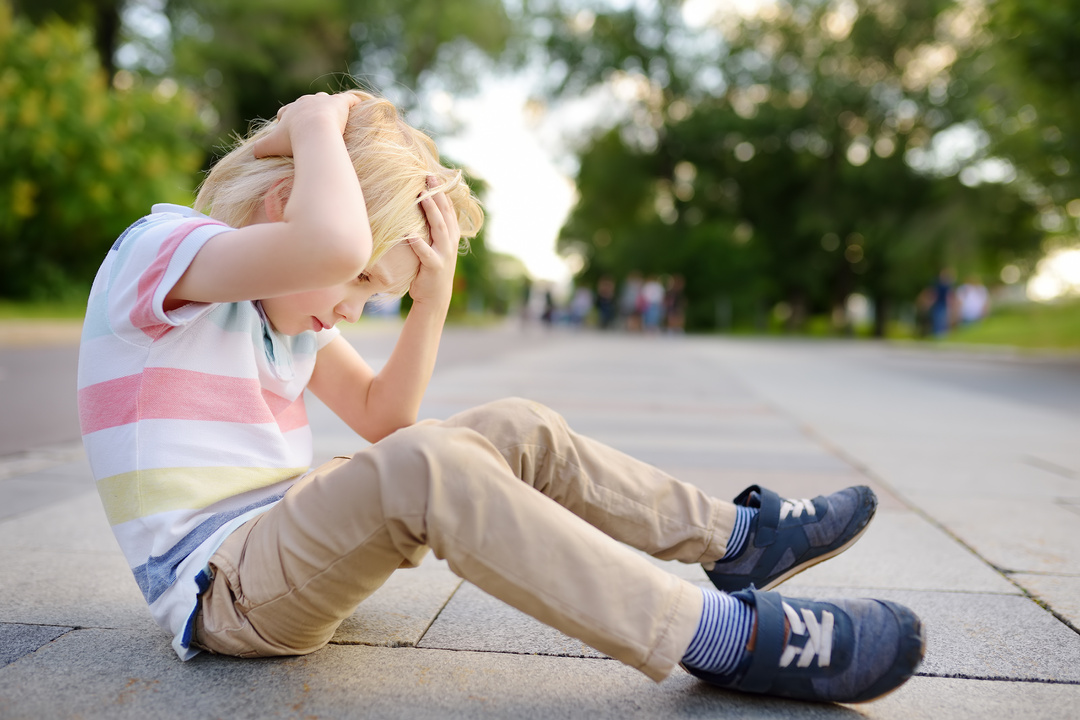 Little Boy Holding Head After Falling on the Ground